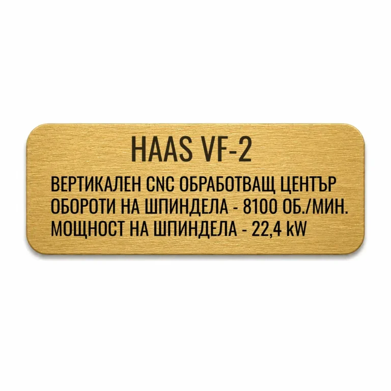 Златиста гравирана индустриална табелка с надпис „HAAS VF-2“ и технически спецификации на вертикален CNC обработващ център