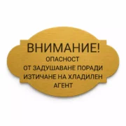 Златиста гравирана индустриална табелка с надпис „ВНИМАНИЕ! ОПАСНОСТ ОТ ЗАДУШАВАНЕ ПОРАДИ ИЗТИЧАНЕ НА ХЛАДИЛЕН АГЕНТ“